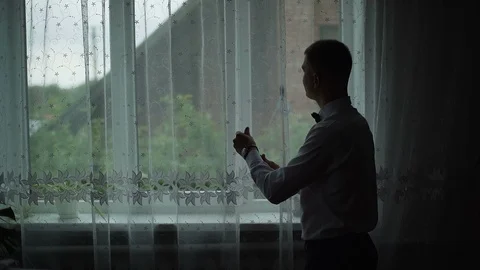 Young man admire view from window at home and put on a shirt. Slow motion Stock Footage 95992404