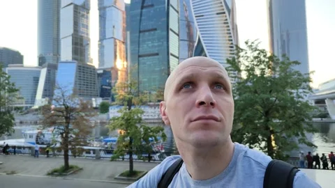Young man admires architecture of modern city Vidéo 201635916
