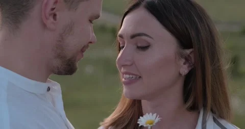 Young man adorns his girlfriend's hair with flower Stock Footage 136043587