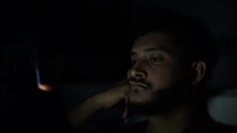 Young man affected by insomnia scrolling on smartphone at night Stock Footage 301087909