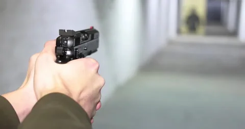 Young man aiming pistol at target in shooting range, slow motion 스톡 동영상 232502986