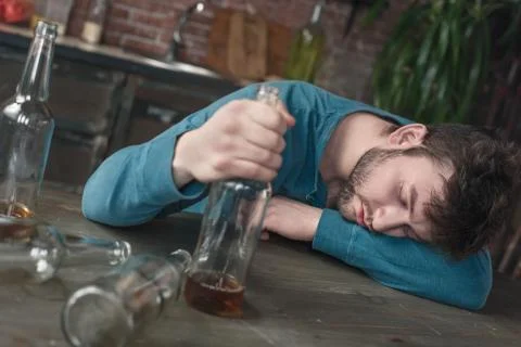 Young man alcoholic social problems concept sleeping drunk Stock Photos
