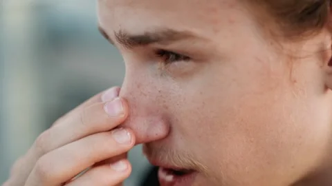 Young man allergic. Closeup of man experiencing allergy during outdoor activity Stock Footage 334946656