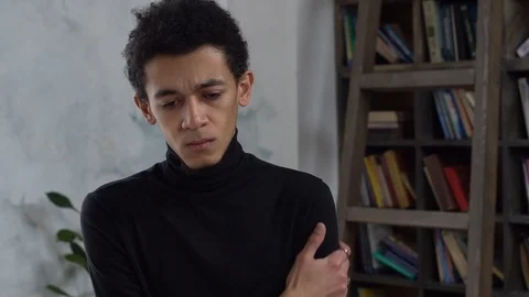 Young man alone in library crossed arms thoughtful Stock Footage 121589819