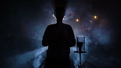 Young man alone smokes hookah exhaling clouds smoke. Stock Footage 149248094