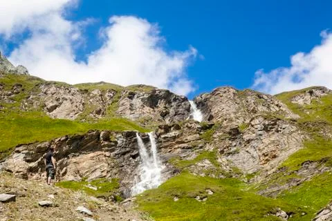 A young man at the alpine waterfall Foto stock