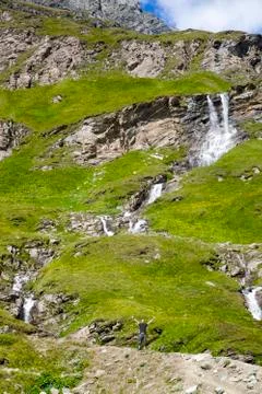 A young man at the alpine waterfall Foto stock