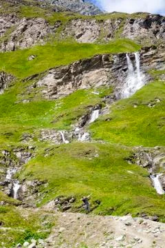 A young man at the alpine waterfall Stock Photos