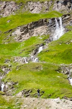 A young man at the alpine waterfall Stock Photos