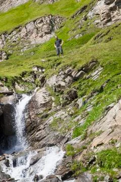 A young man at the alpine waterfall Stock Photos