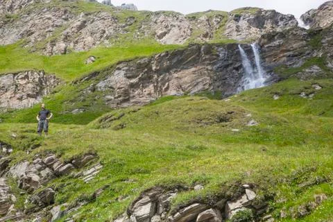 A young man at the alpine waterfall Stock Photos