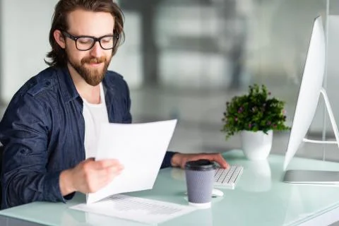 Young man analyzing financial data in the office Stock Photos