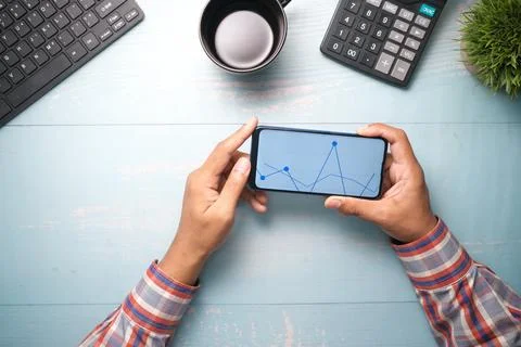 Young man analyzing stock chart on smart phone Stock Photos
