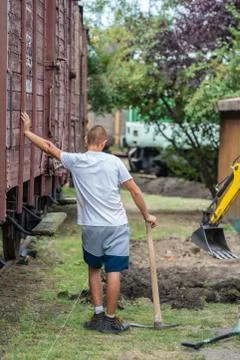 Young man and digger at work Stock Photos