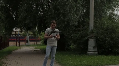 The young man and the drone in the summer garden Video stock 77627407