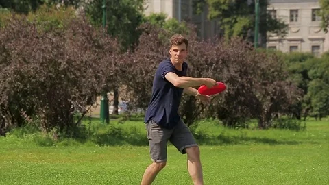Young man and his charming girlfriend are playing a frisbee game on a lawn in Stock Footage 75002417