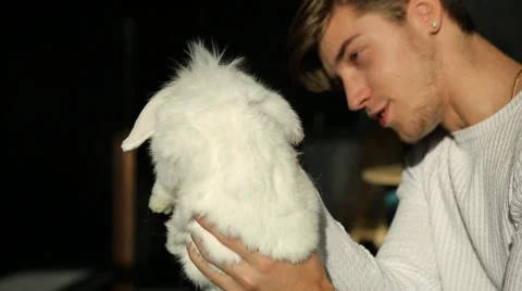 Young man and white rabbit Stock Footage 61848813