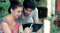young man and woman are having fun looking at photos with your tablet HD Footage