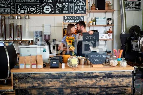 Young man and woman owner working at new open caf. Stock Photos