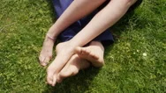 Young Man And Young Woman Rubbing Their Feet Together In The Park Stock Footage