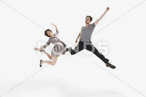 A young man and a young woman jumping mid-air Stock Photos
