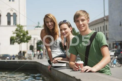 Young man and young women at fountain Stock Photos