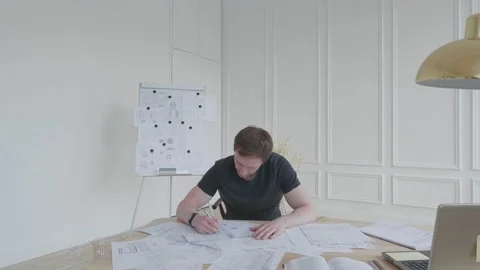 A young man in anger sweeps documents from the table. Stock Footage 131277981