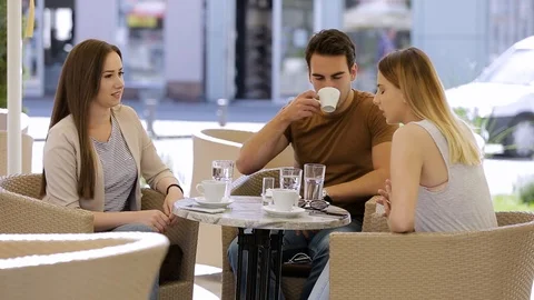 Young man answering the phone while sitting on coffee with his friends Stock Footage 87392741
