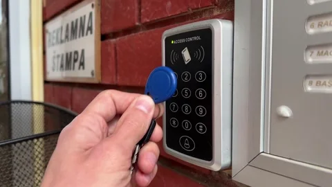 A young man applies a wireless key to the reader to open the front door Stock Footage 241494773
