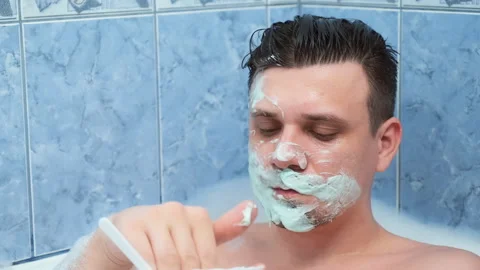 Young man is applying alginate mask lying in bathroom with foam at home. Video stock 158843981
