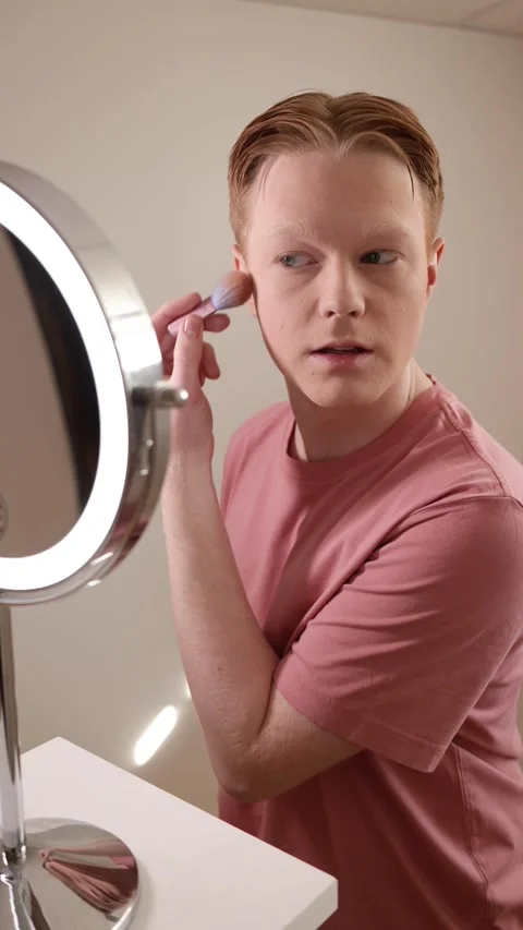 A Young Man Applying Blush In Front Of A Ring Light Mirror Stock Footage 309903919