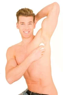 Young man applying deodorant Stock Photos