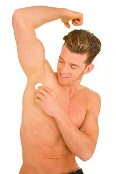 Young man applying deodorant Stock Photos