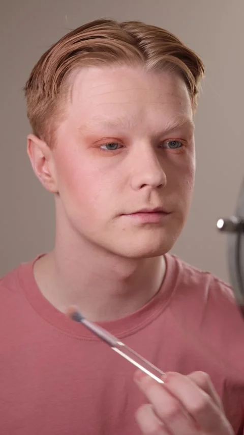 A Young Man Applying Eyeshadow in Front of Mirror Stock Footage 310161532