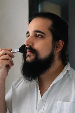 Young man applying make-up. Size view of a boy applying make-up. Stock Photos