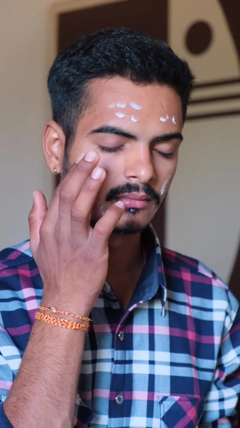 Young man applying moisturizing cream dots on his forehead and face Stock Footage 331354654