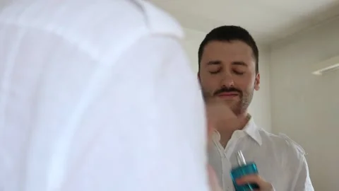 Young Man applying perfume Stock Footage 158506336