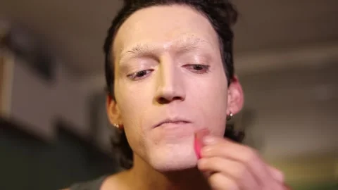Young man applying theatrical foundation makeup Stock Footage 326065578