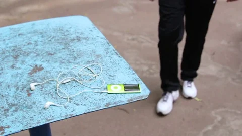 A young man approaches the table and takes an audio player Stock Footage 84758206
