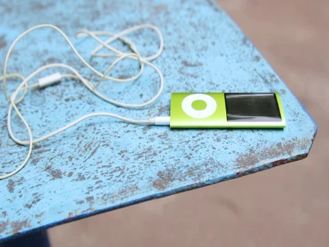 A young man approaches the table and takes an audio player Stock Footage 84758238
