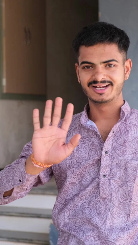 Young Man Approaching Camera Saying Hello with Friendly Smile and Hand Gesture Видео 330738329