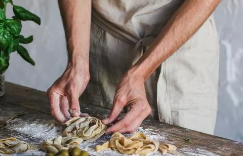 The young man in an apron preparing homemade pasta Stock Photos