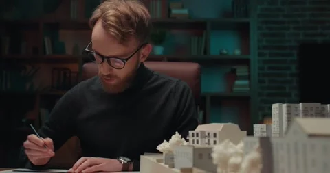 Young man architect working with blueprints using pencil and ruler. Stock Footage 242987404