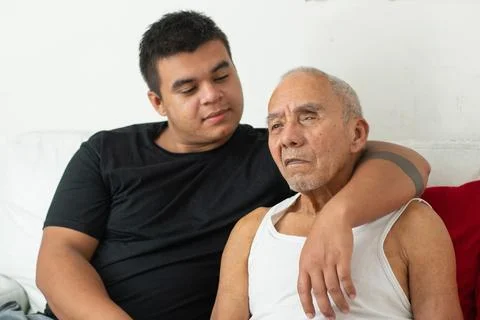 Young man with arm around elderly father showing affection and emotional fa.. Stockfoto's