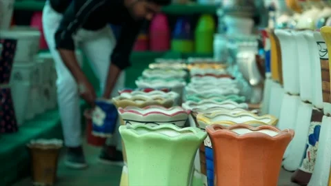 A young man arranging beautiful ceramic pots together in a nursery Video stock 170681679