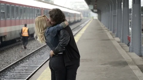 Young man arriving in train station finding his girlfriend eager to meet with Stock Footage 78119098