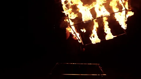 A young man, an artist, performs with a fiery metal cube. Stock Footage 246222208