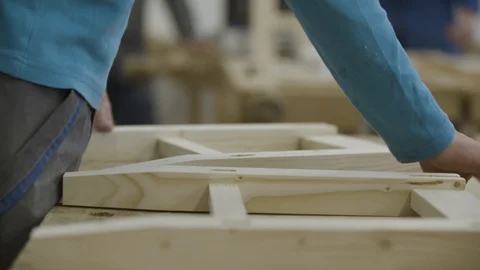 Young man is assembling pieces of wood Stockbeeldmateriaal 92672257