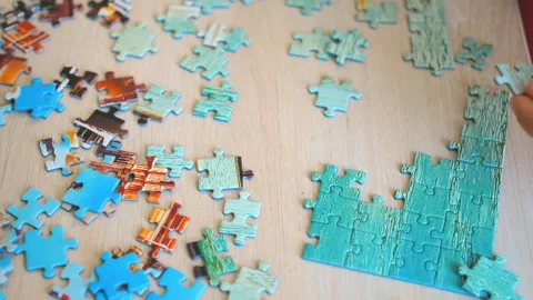 Young man assembling puzzle, cognitive development. puzzle medium skill Stock Footage 258451481