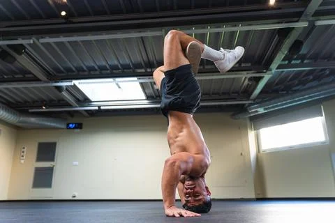 Young man with an athletic body practicing breakdance indoors Foto stock